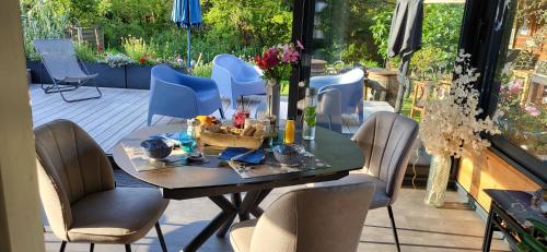 Une table à manger et des chaises sont disponibles sur la terrasse. dans l'établissement Maison bretonne proche plage, à Pénestin
