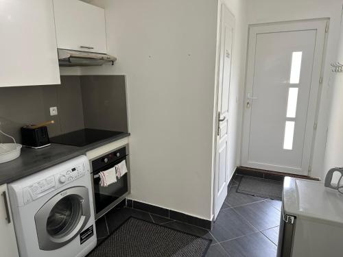 une cuisine avec une machine à laver et un lave-linge dans l'établissement Calme proche Paris, à Villejuif