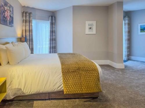 a bedroom with a large bed and a window at The Carrigart Hotel in Carrigart