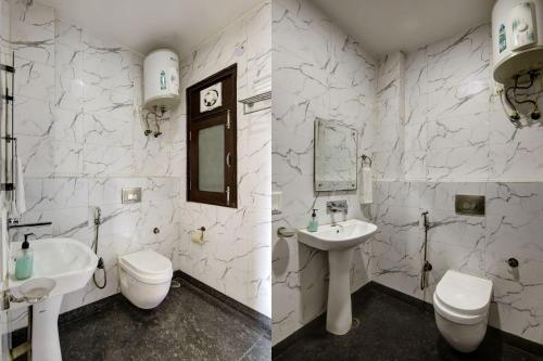a white bathroom with a sink and a toilet at The Embassy Inn - Sector 20 Noida in Noida