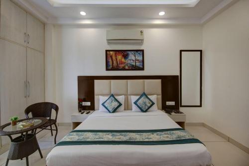 a hotel room with a bed and a table and a mirror at The Embassy Inn - Sector 20 Noida in Noida