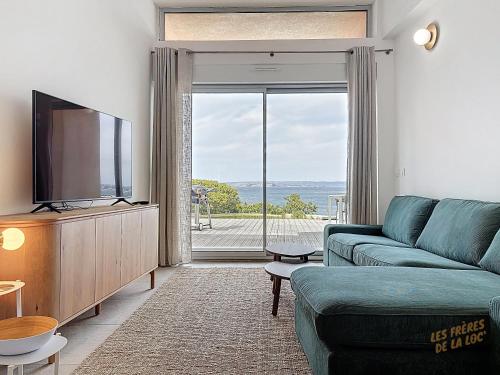 un salon avec un canapé et une télévision à écran plat dans l'établissement Maison Unique - Piscine au dessus de la mer - Les Frères de la Loc', à Marseille