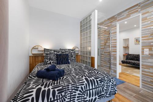 - une chambre avec un lit noir et blanc dans l'établissement Nice Renting - 5 Massena - Elegant Air-Conditioned Cocoon Quiet Patio Massena, à Nice