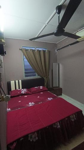 a bedroom with a red bed with a window at Homestay Rezeki Batu Gajah in Batu Gajah