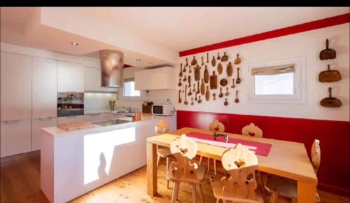 a kitchen with a wooden table and a red wall at Beautiful Red, La Punt Chamues - Engadin in Ponte