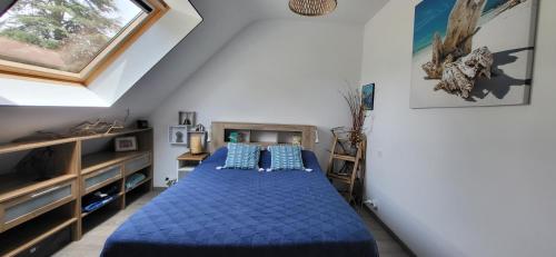 a bedroom with a bed with blue sheets and a window at Maison bretonne proche plage in Pénestin
