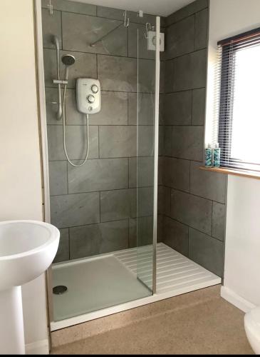 a shower with a glass door in a bathroom at Little Hare Lodge - Near Ludlow in Lane to Richards Castle