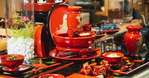 a display of red dishes and vases on a table at HOTEL SANSUI NAHA Ryukyu Onsen Naminoue-No-Yu in Naha