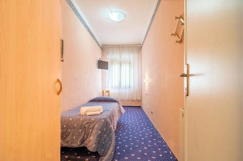 a hotel room with a bed and a corridor at Hotel Marnie in Massarosa