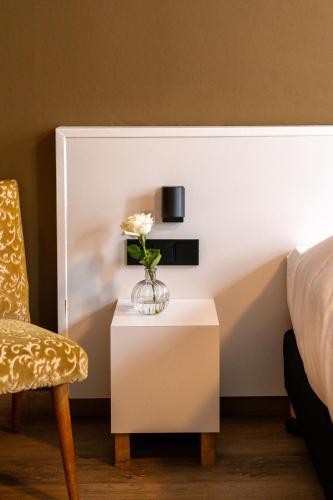 a bedroom with a bed and a table with a vase of flowers at Restaurant & Hotel Monopole Harderwijk in Harderwijk