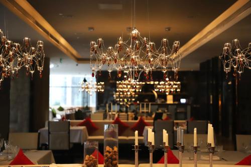 a dining room with chandeliers and a table with candles at Sofitel Guangzhou Sunrich - Free Shuttle Bus to Canton Fair Complex & Overseas Buyer Registration Services during Canton Fair Period in Guangzhou