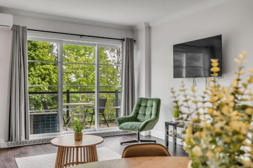 a living room with a large window and a table and chairs at INITIAL - Escapade - Chutes-Montmorency in Boischâtel