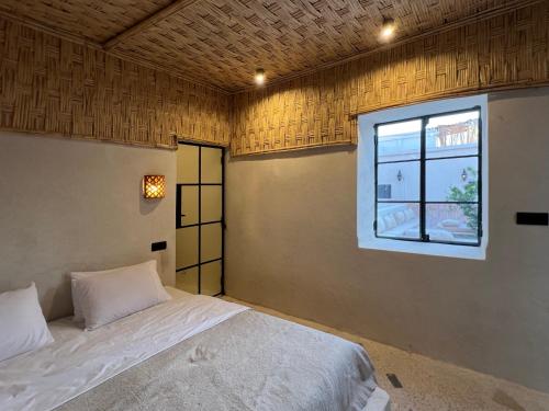 a bedroom with a bed and a window at Riad Ait Sonia in Tamraght Ouzdar