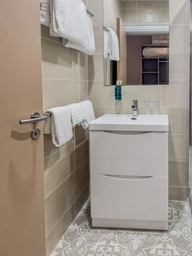 a white bathroom with a white sink and towels at The Carrigart Hotel in Carrigart