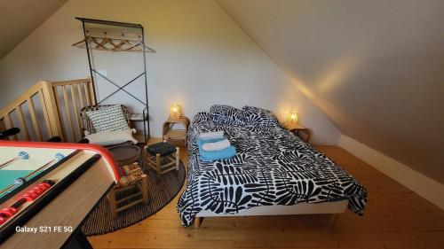 une chambre avec un lit avec une couverture noire et blanche dans l'établissement Au pied de la Chartreuse, à Saint Bernard du Touvet