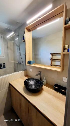 une salle de bain avec un lavabo noir et un miroir dans l'établissement Au pied de la Chartreuse, à Saint Bernard du Touvet