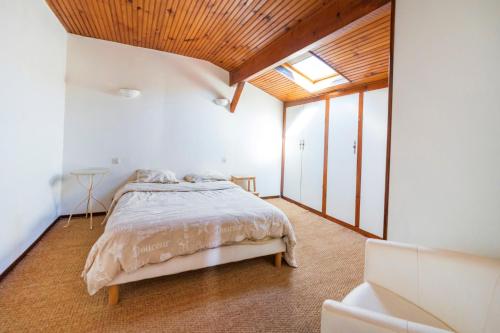 a bedroom with a bed with a wooden ceiling at Joli T3 Pays Basque Tarnos Landes in Tarnos