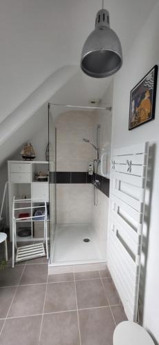a bathroom with a shower with a glass door at Maison bretonne proche plage in Pénestin