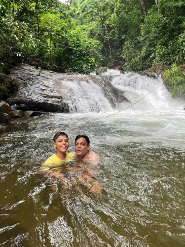 a man and a boy are swimming in a river at Green and Green in Vagamon
