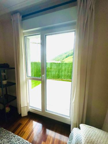 a room with a large glass door with a window at Reformado con Piscina y Jardín in Gibaja