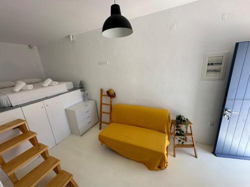 a room with a yellow chair and a bed at Serenity Nest Serifos in Serifos Chora