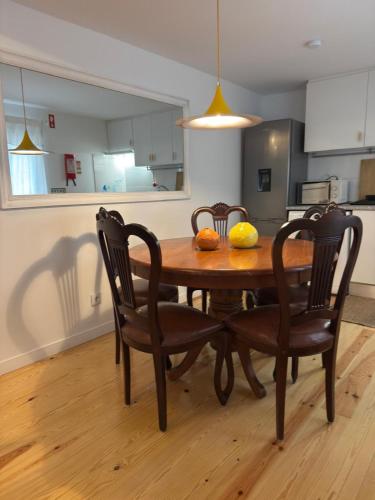 a dining room table with two chairs and fruit on it at Idyllic, Charming Quinta das Laranjeiras in Alcácer do Sal