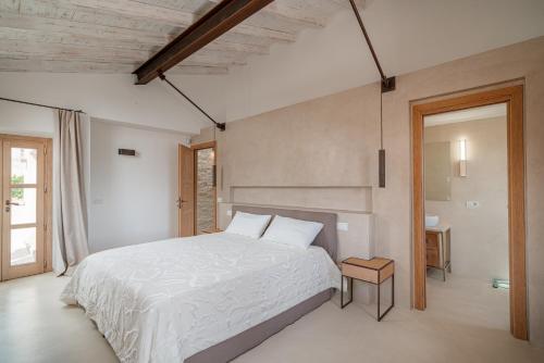 a bedroom with a large white bed in a room at Villa dell'800 con Jacuzzi Privata - San Pantaleo in San Pantaleo