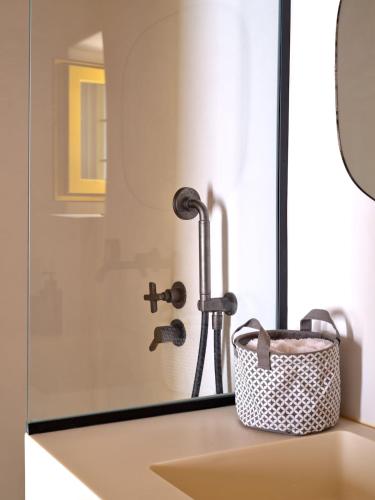 a bathroom with a shower and a basket on a counter at Yellow Stone in Kampos Paros