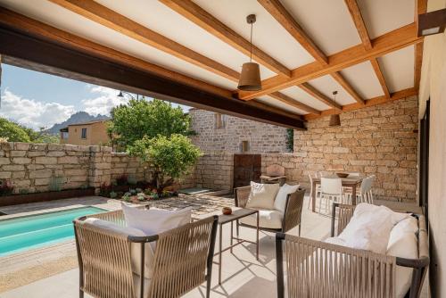 a patio with a table and chairs and a swimming pool at Villa dell'800 con Jacuzzi Privata - San Pantaleo in San Pantaleo