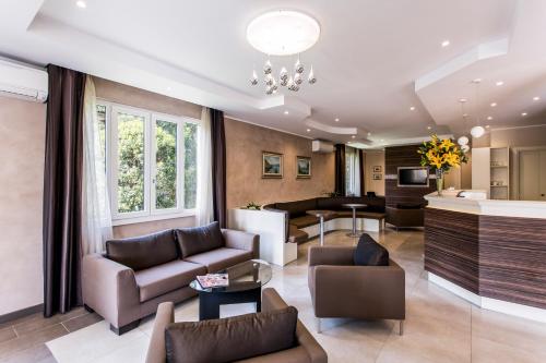 a living room with two couches and a kitchen at Hotel Sorriso in Toscolano Maderno