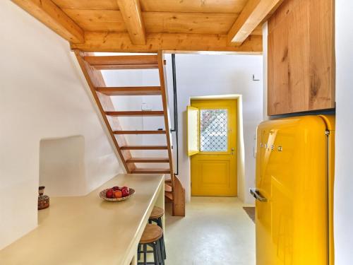 a kitchen with a yellow refrigerator and a yellow door at Yellow Stone in Kampos Paros