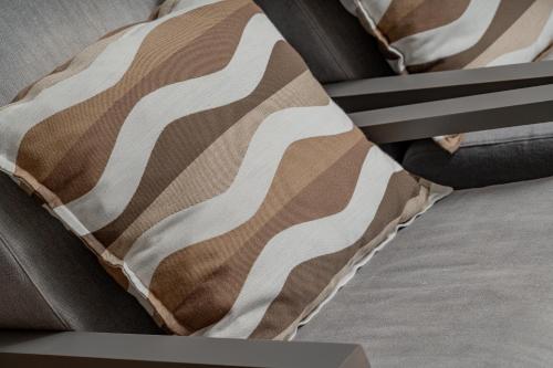 a brown and white pillow sitting on a bed at Villa dell'800 con Jacuzzi Privata - San Pantaleo in San Pantaleo