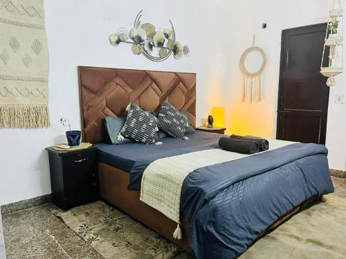 a bedroom with a large bed with blue sheets and pillows at Goaround Homes Kalkaji, South Delhi in New Delhi