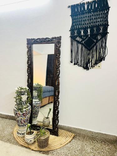 a mirror and some plants on a table at Goaround Homes Kalkaji, South Delhi in New Delhi