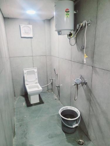 a small bathroom with a toilet and a bucket at Heart Beat Resort in Shivpuri