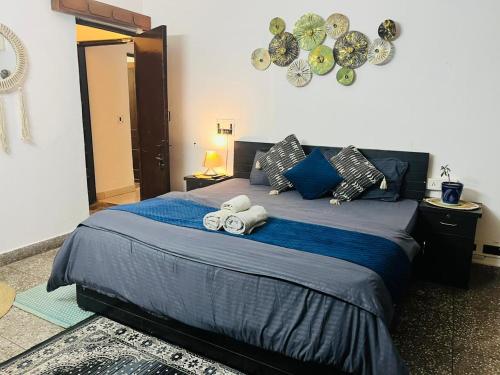 a bedroom with a large bed with towels on it at Goaround Homes Kalkaji, South Delhi in New Delhi