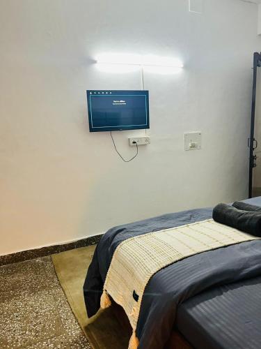 a bedroom with a flat screen tv on the wall at Goaround Homes Kalkaji, South Delhi in New Delhi