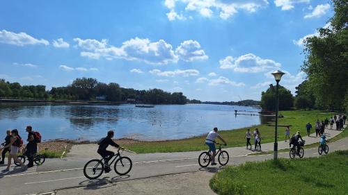 a group of people riding bikes by a lake at Wooden house Ada in Ada Ciganlija