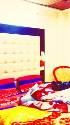 a bedroom with a bed with a white headboard at Ridge Lakkar Stay in Shimla