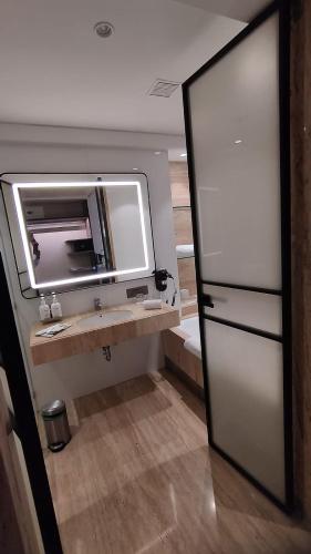 a bathroom with a mirror and a sink at Mirage Hotel, Mumbai International Airport in Mumbai