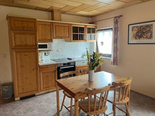 a kitchen with wooden cabinets and a wooden table with chairs at Landgasthof - Hotel zum Stern in Linden