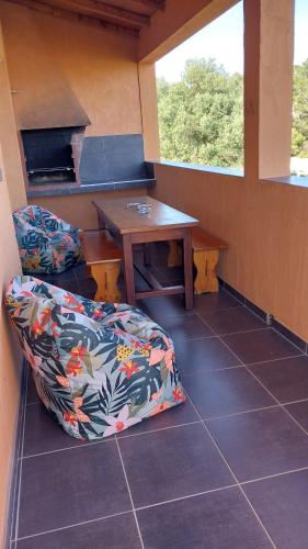 Cette chambre comprend un canapé, une table et une fenêtre. dans l'établissement cASAPIANA 7, à Porto-Vecchio