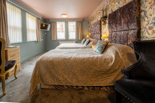 a bedroom with a large bed and a chair at Brockley Hall Hotel in Saltburn-by-the-Sea