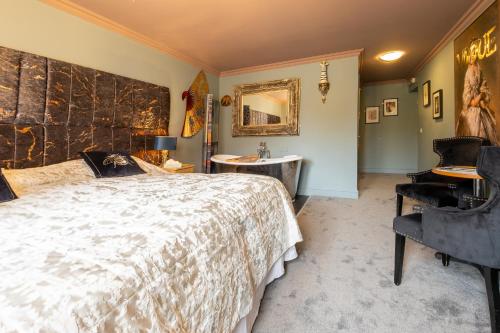 a bedroom with a bed and a tub and a sink at Brockley Hall Hotel in Saltburn-by-the-Sea