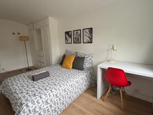 a bedroom with a bed and a desk and a red chair at La Prairie - Colocation cosy au cœur des Universités in Bures-sur-Yvette