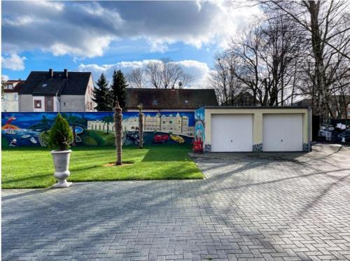 a house with two garage doors and a mural at Tropical in Recklinghausen