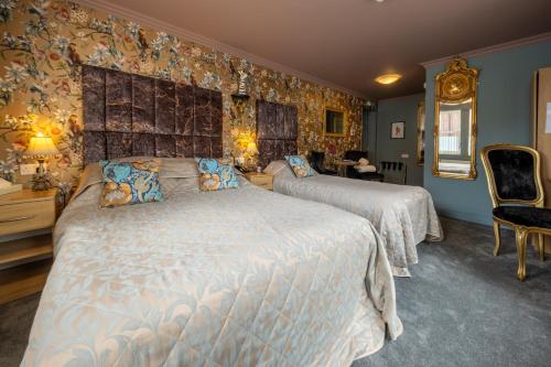 a bedroom with two beds in a room with wallpaper at Brockley Hall Hotel in Saltburn-by-the-Sea