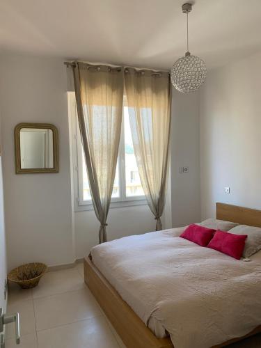 une chambre avec un grand lit avec des oreillers rouges dans l'établissement Apartment Center Sea View Garage Conciergerie, à Sanary-sur-Mer