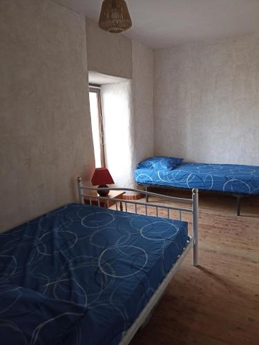 deux lits dans une chambre avec une fenêtre dans l'établissement chambre pour 3, à Osmanville