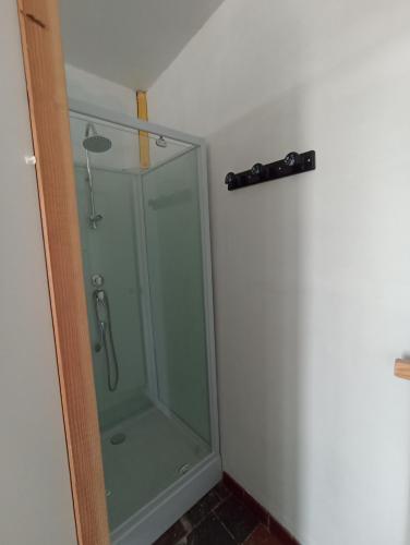une douche avec une porte vitrée dans une salle de bain dans l'établissement chambre pour 3, à Osmanville